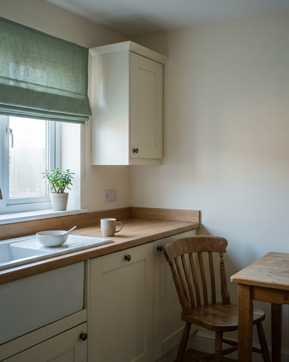 An empty kitchen in early morning light, a mug of tea left untouched on the worktop.